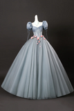 Gray ball gown with floral details on a mannequin against a black background