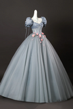 Gray ball gown with floral details on a mannequin against a dark background