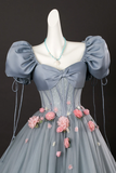 Gray gown with floral details on a mannequin against a black background