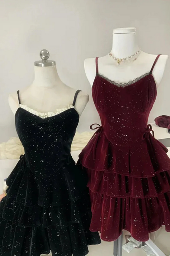 Black and burgundy sparkly dresses on mannequins against a neutral background