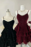 Black and burgundy sparkly dresses on mannequins against a neutral background