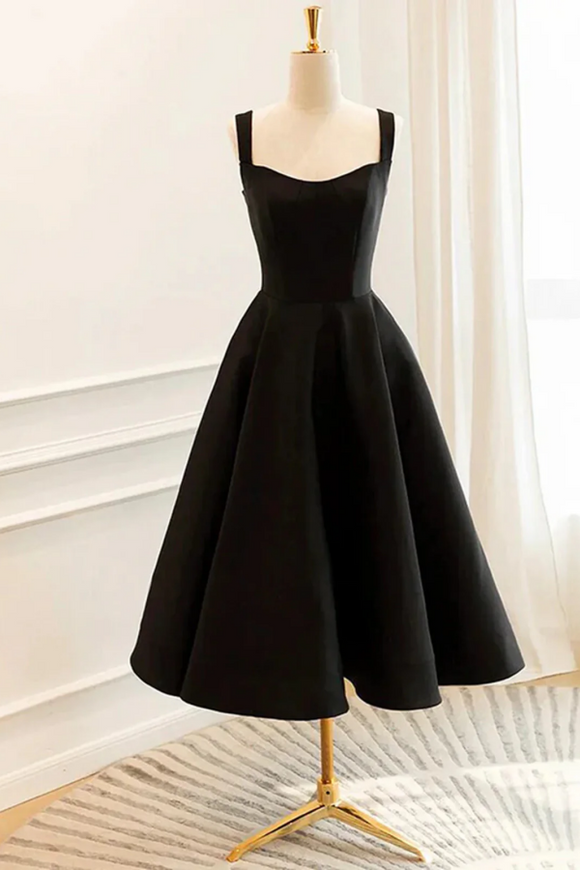 Black dress on a mannequin against a white curtain background