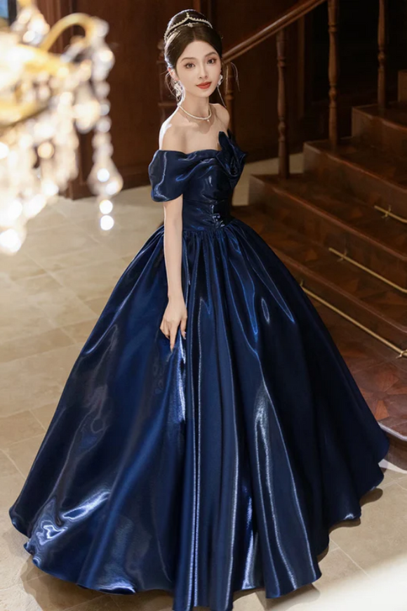 Woman in a blue evening gown standing in an elegant interior setting.