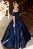 Woman in a blue evening gown standing in an elegant interior setting.
