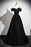 Black evening gown on a mannequin against a white wall