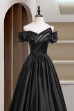 Black off-shoulder dress on a mannequin against a neutral background
