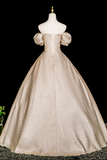 Beige vintage gown on a mannequin against a black background
