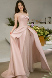Woman wearing a strapless pink gown with a sheer overlay in an indoor setting.