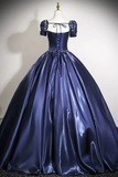 Navy blue satin ball gown on a mannequin against a neutral background