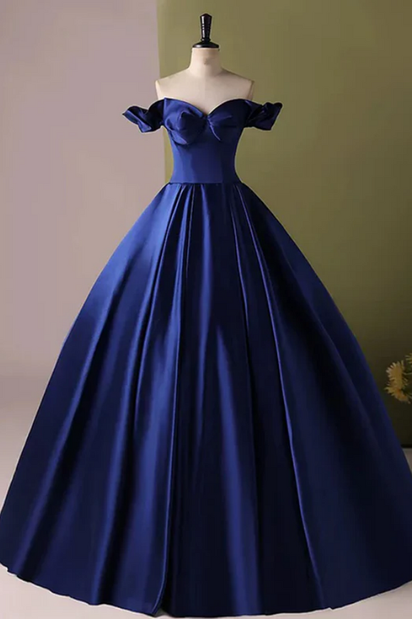 Navy blue off-shoulder gown on a mannequin against a green wall.