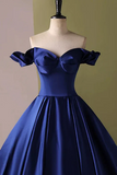 Navy blue off-shoulder dress on a mannequin against a green background
