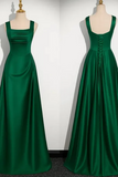 Two green evening gowns on mannequins against a white background