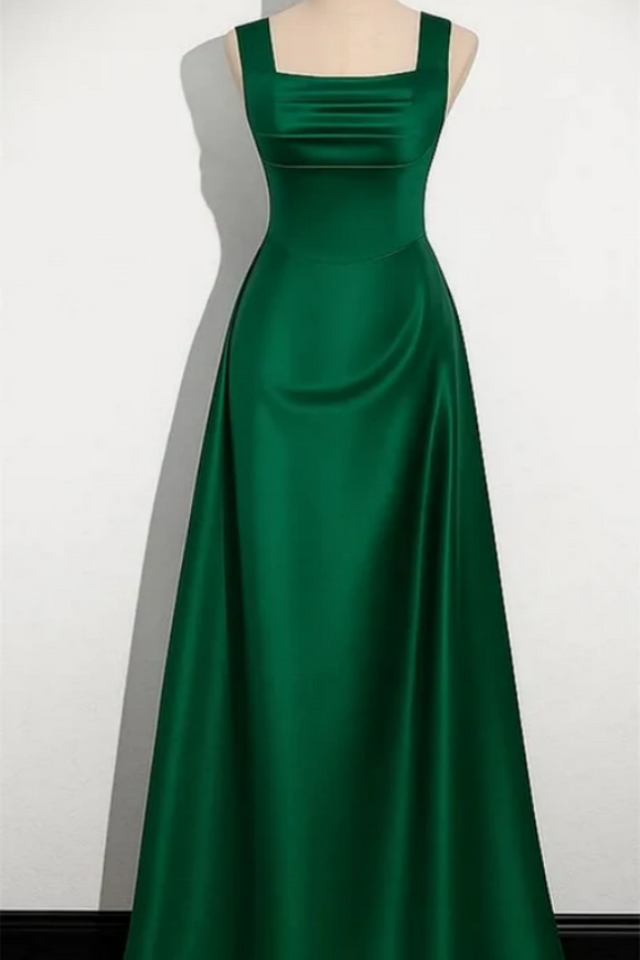 Green evening gown on a mannequin against a white background