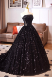 Black sequin dress on a mannequin in a room with a couch and framed pictures.