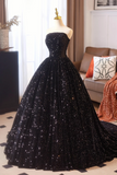 Black sequin gown on a mannequin in a room with a sofa and decorative pillows.