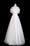 White off-shoulder dress on a mannequin against a black background