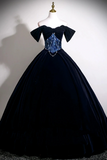 Black evening gown with blue sequin detailing on a mannequin against a white background