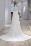 White wedding dress with a long train on a mannequin in an indoor setting.