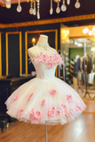 White dress with pink floral embroidery on a mannequin in a store setting.