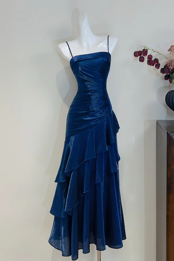 Blue evening gown on a mannequin against a plain background