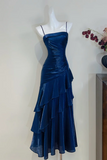 Blue evening gown on a mannequin against a plain background