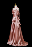 Pink satin evening gown on a mannequin against a black background
