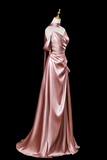 Pink satin evening gown on a mannequin against a black background