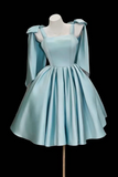 Light blue dress with cape on a mannequin against a black background