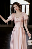 Woman in a pink dress holding a handbag in an indoor setting