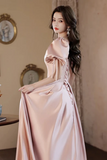 Woman in a pink evening gown standing in an elegant room.