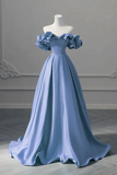 Blue evening gown on a mannequin against a gray wall.
