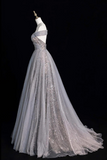 Elegant silver evening gown on a mannequin against a black background