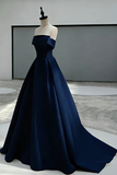 Navy blue evening gown on a mannequin against a neutral background