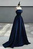 Navy blue evening gown on a mannequin against a neutral background