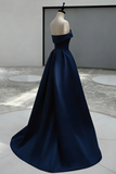 Navy blue evening gown on a mannequin against a neutral background