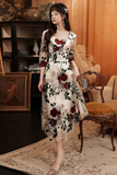 Woman in a floral dress standing in an elegant room with vintage decor.