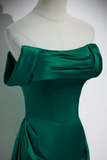 Green off-shoulder dress on a mannequin against a plain background
