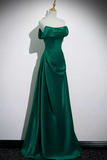 Green evening gown on a mannequin against a white background