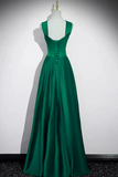 Green evening gown on a mannequin against a white background