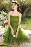 Woman in a green dress standing outdoors with blurred background