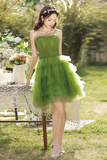 Woman in a green dress standing outdoors with blurred background