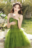 Woman in a green dress holding an ice cream cone in a garden setting