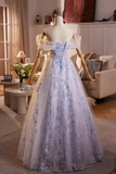 Blue floral evening gown on a mannequin in a room with decor.