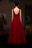 Red evening gown with a low back on a dark background
