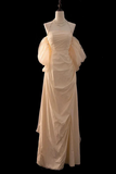 Beige evening gown on a mannequin against a black background