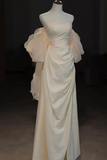 White evening gown on a mannequin against a dark background