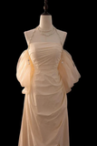 Beige evening gown on a mannequin against a black background