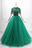 Green evening gown on a mannequin against a white wall