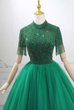 Green beaded dress on a mannequin against a white background