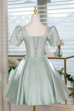 Mint green dress on a mannequin with a blurred indoor background